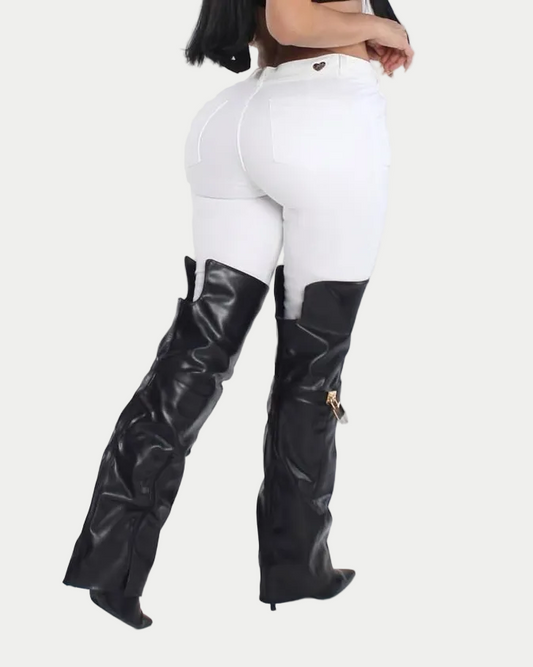 Person wearing black knee-high boots and white pants on a white background